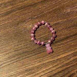 This is a purple bracelet with a bear charm.